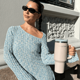 Jente i blå kjole holder en lyserosa tumbler