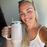Jente holder opp en lyserosa tumbler